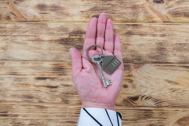 Clés d'un appartement ou d'une maison sur la paume de votre main La main d'une femme tient un porte-clés en métal avec des clés