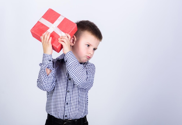 Client. Achats. Le lendemain de Noël. Nouvelle année. petit garçon avec un cadeau pour la Saint Valentin. vendeur. Enfance heureuse. enfant heureux avec boîte présente. Noël. Fête d'anniversaire. client sérieux. espace de copie.