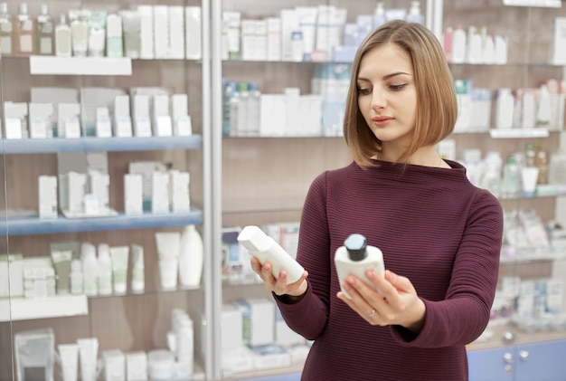 Client choisissant des produits cosmétiques en apothicaire.