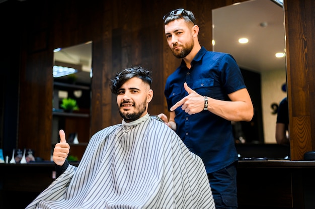 Client et coiffeur regardant la caméra