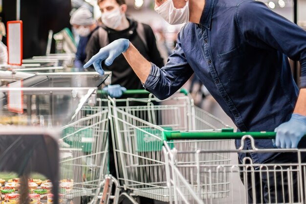 Client en gants de protection en choisissant des produits dans un supermarché. hygiène et soins de santé