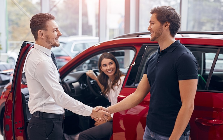 Photo client et gestionnaire concluant un accord dans la concession automobile