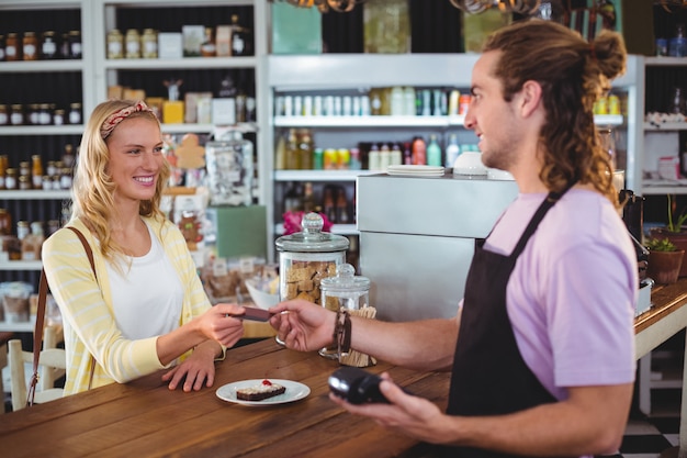 Client heureux donnant la carte de crédit au serveur