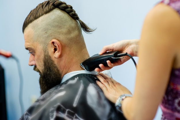 Client de hipster visitant le salon de coiffure. La mode masculine. Homme barbu après salon de coiffure. Hipster homme