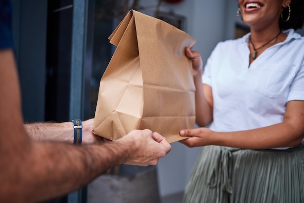 Photo client de livraison et mains avec un sac en papier à la porte de l'homme de messagerie à la maison