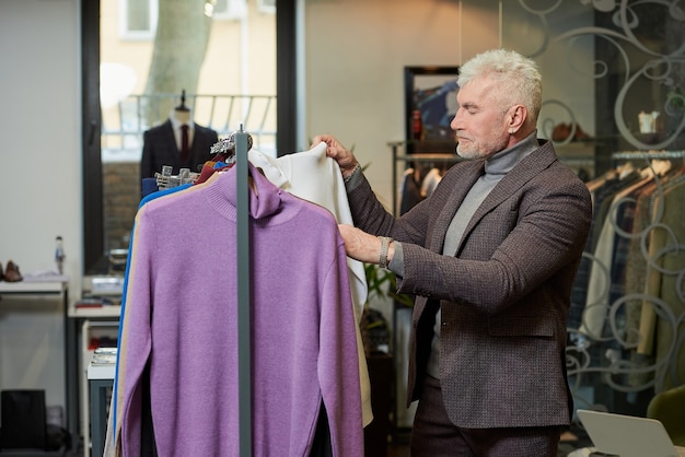 Un client masculin avec une barbe porte un costume dans une boutique.