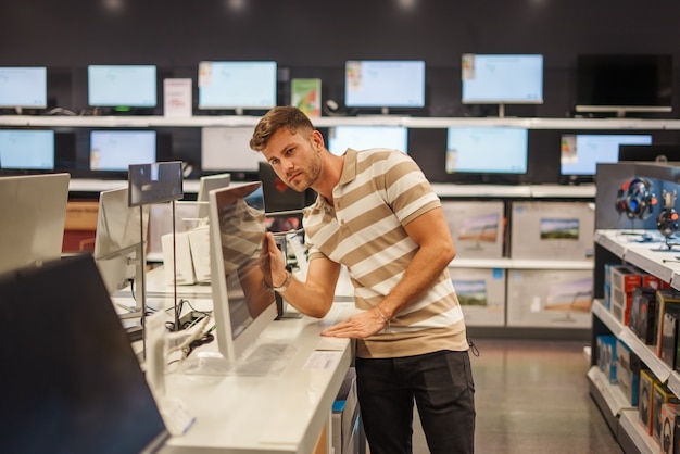 Client masculin sélectionnant le moniteur dans la boutique