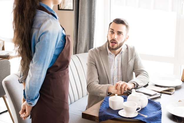 Client pensif demandant serveuse au café