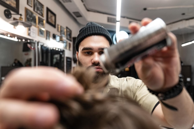 Photo le client reçoit une coupe de cheveux et une coiffure dans un salon de beauté. le coiffeur est au service du client.