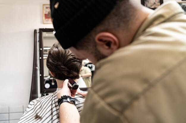 Photo le client reçoit une coupe de cheveux et une coiffure dans un salon de beauté. le coiffeur est au service du client.