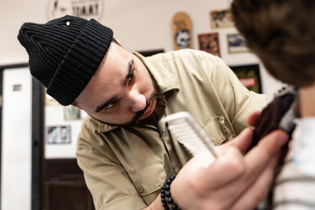 Le client reçoit une coupe de cheveux dans un salon de coiffure. Soins des cheveux pour hommes. Coupe de cheveux aux ciseaux