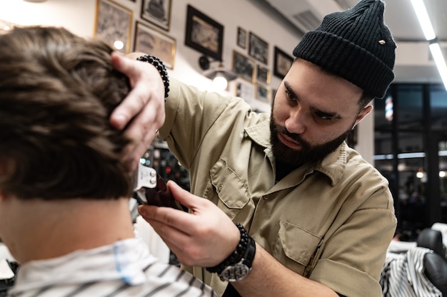 Le client reçoit une coupe et une coiffure dans un salon de beauté. Barber sert le client.