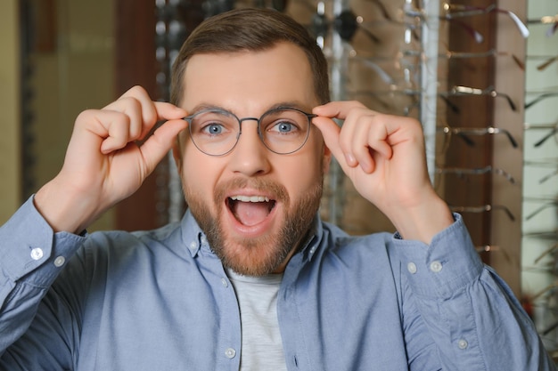 Client satisfait Vue sur l'épaule d'un jeune homme heureux portant de nouvelles lunettes