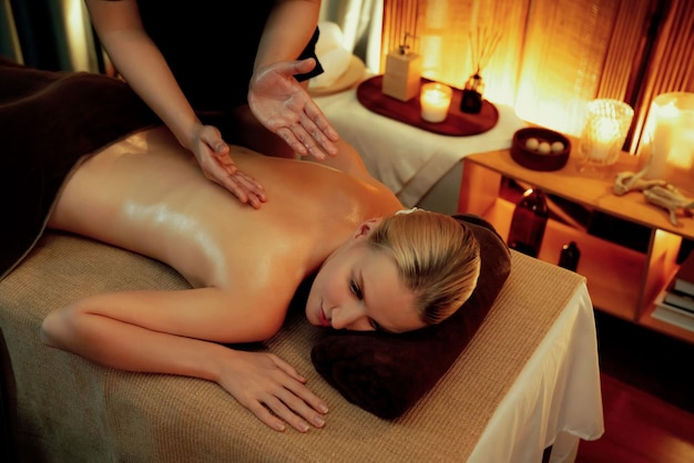 Une cliente caucasienne profitant d'un spa relaxant, d'un massage antistress et d'un pampering avec la beauté de la peau, de loisirs dans un salon spa à l'éclairage de bougies chaudes dans un complexe de luxe ou un hôtel tranquille