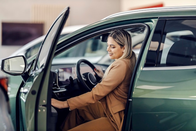 Une cliente essaie une nouvelle voiture qu'elle veut acheter au centre de concession automobile