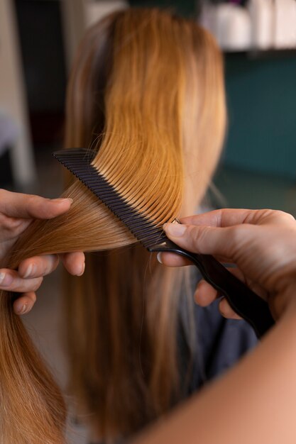 Photo une cliente se fait coiffer au coiffeur.