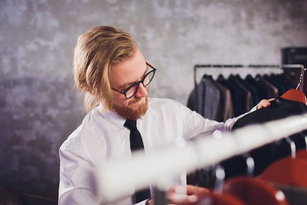 Clientèle masculine à la recherche d'une veste dans le magasin de vêtements pour hommes.