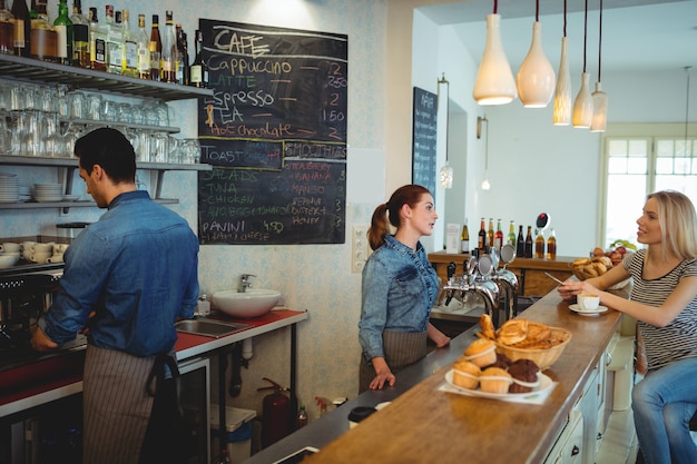 Clientèle parlant avec barista au café