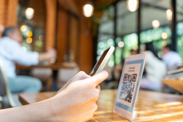 Photo les clients utilisent des smartphones pour scanner les codes qr afin de payer en magasin avec des paiements numériques sans scanner d'espèces. obtenez des réductions technologie de portefeuille électronique paiement en ligne application bancaire transfert d'argent en ville intelligente