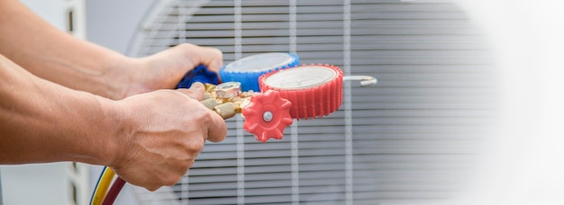 Climatisation, technicien de service HVAC utilisant des jauges pour vérifier le réfrigérant et ajouter du réfrigérant.