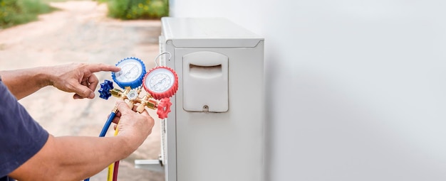 Climatisation, technicien de service HVAC utilisant des jauges pour vérifier le réfrigérant et ajouter du réfrigérant.