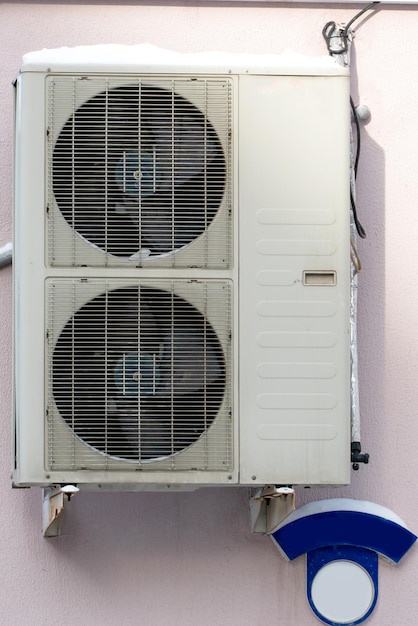 Un climatiseur extérieur composé de deux ventilateurs Un grand climatiseur industriel sur le mur d'un magasin ou d'une entreprise Réparation et entretien du système de climatisation