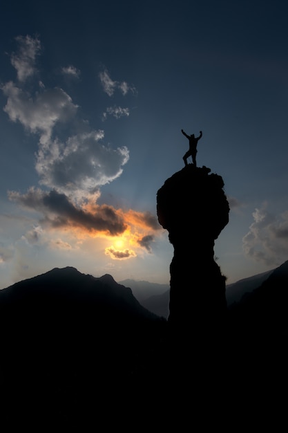 Climber se réjouit après avoir conquis le sommet les mains levées