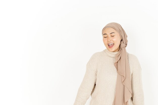 Clin d'oeil à l'appareil photo de la belle femme asiatique portant le hijab isolé sur fond blanc