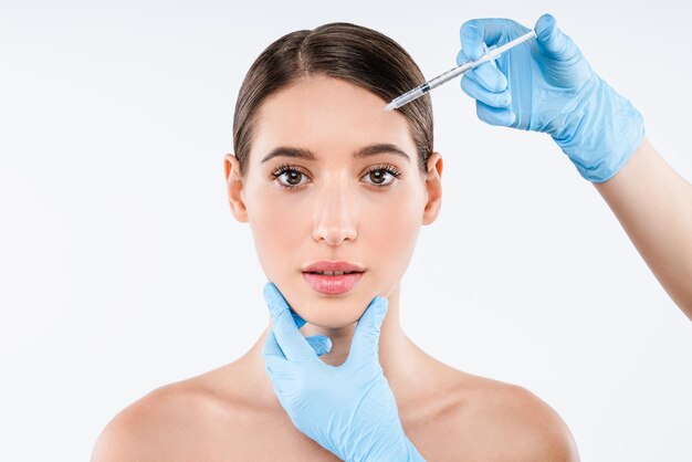 Photo clinique de chirurgie plastique une belle femme reçoit une injection dans le visage