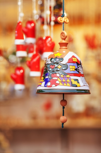 Cloche en céramique colorée vendue sur le marché de Noël en Europe. Cadeau souvenir d'argile de cloche à la foire.