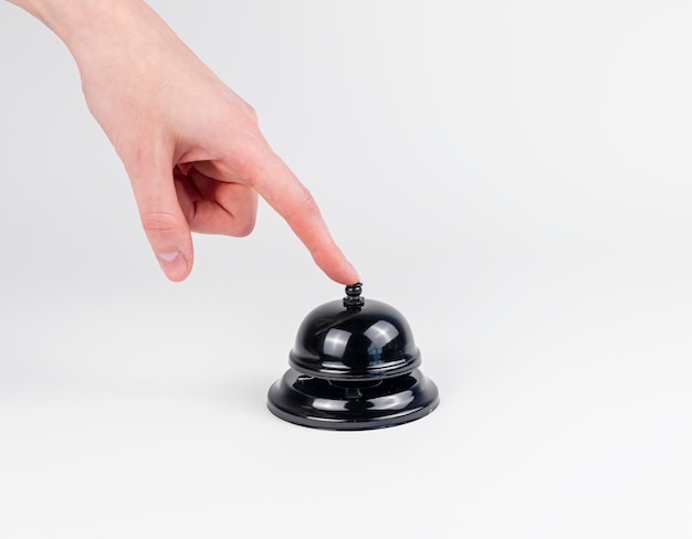 La cloche du bureau est pressée par une image de concept de main féminine sur fond blanc