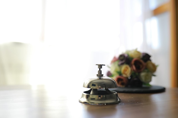 Cloche de service de l'hôtel sur le bureau de réception en bois Espace pour le texte