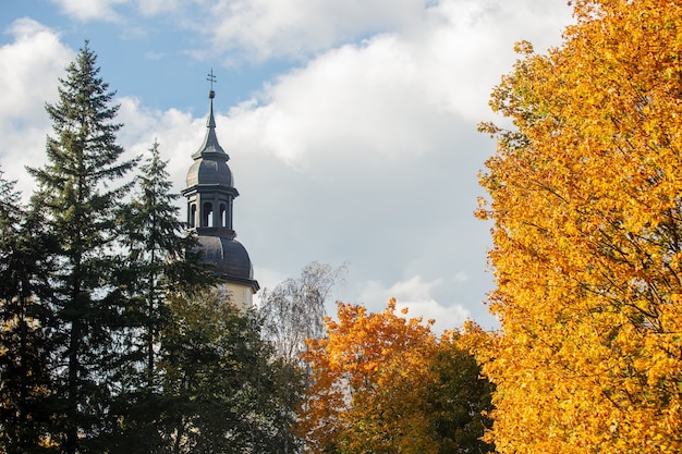 Clocher de l'église au milieu des arbres d'automne