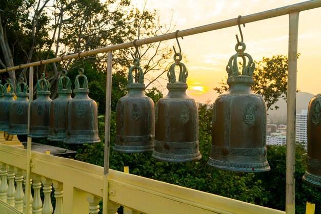 cloches métalliques suspendues dans une rangée à l'extérieur dans un temple bouddhiste thaïlandais, cloche de temple thaïlandaise qui croit que ceux qui frappent cette cloche auront de la chance.