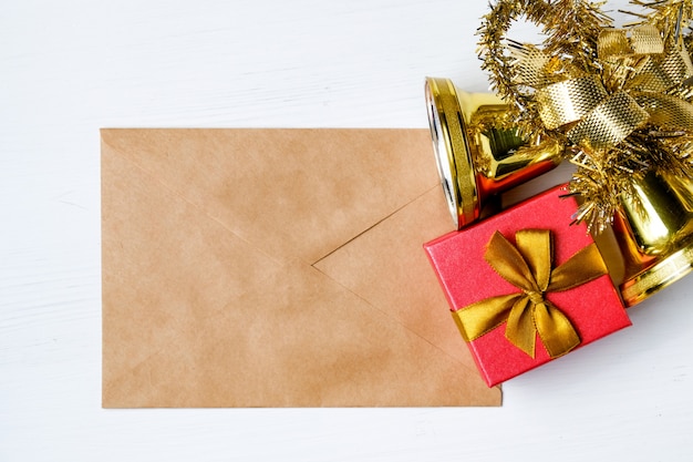 Photo cloches de noël avec guirlandes et cadeau sur enveloppe de papier kraft