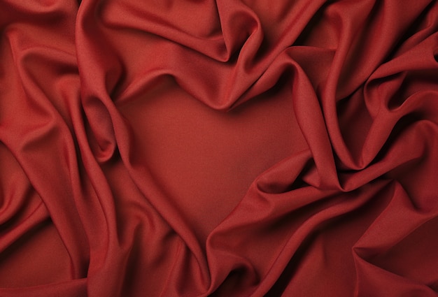 Close up abstract background textile de plis pliés rouges en forme de coeur de tissu, vue de dessus, directement au-dessus