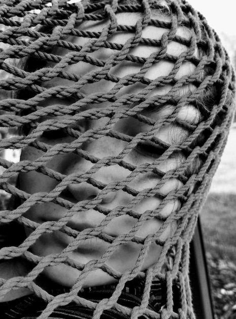 Close-up d'une adolescente avec un filet de pêche sur le visage