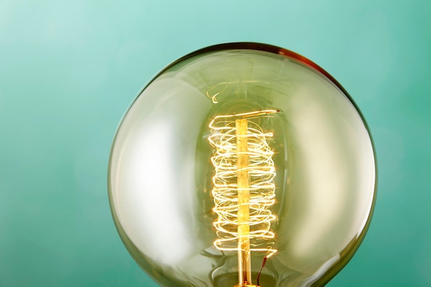 Close-up d'une ampoule éclairée sur un fond bleu