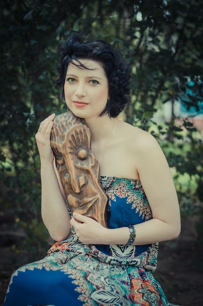 Close-up art portrait d'été d'une jeune femme avec sculpture en bois