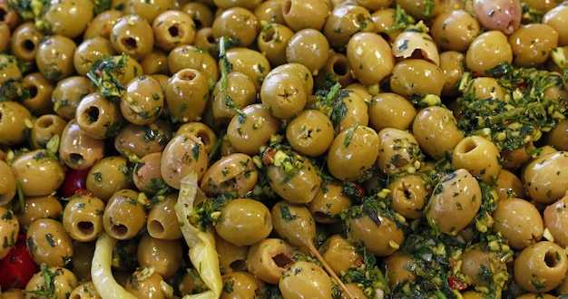 Close up background d'olives vertes marinées artisanales traditionnelles avec des herbes d'épices sur l'affichage de détail du marché ouvert, high angle view