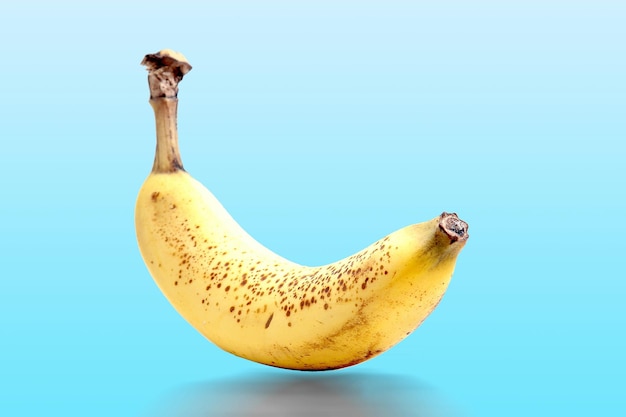 Close-up d'une banane jaune sur un fond bleu