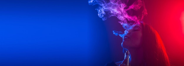 Photo close up banner portrait of vaping girl in neon blue and red light copy space