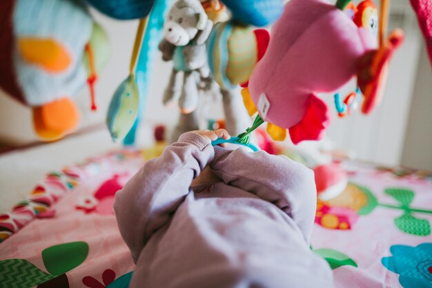 Photo close-up d'un bébé allongé dans un berceau avec des jouets