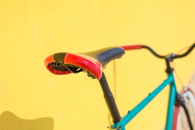 Close-up d'une bicyclette contre un mur jaune