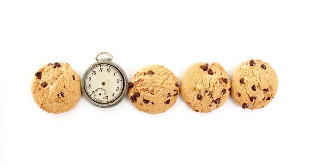 Photo close-up de biscuits avec une montre de poche sur fond blanc