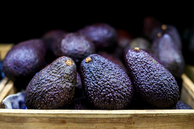 Photo close up black hass avocats mûrs dans le panier sur un étal de supermarché