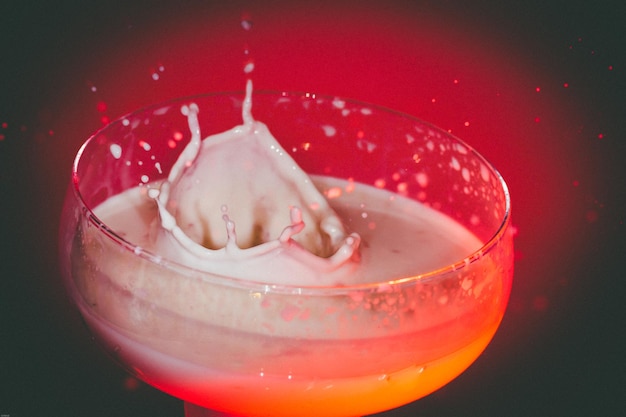 Close-up d'une boisson éclaboussée sur un fond rouge