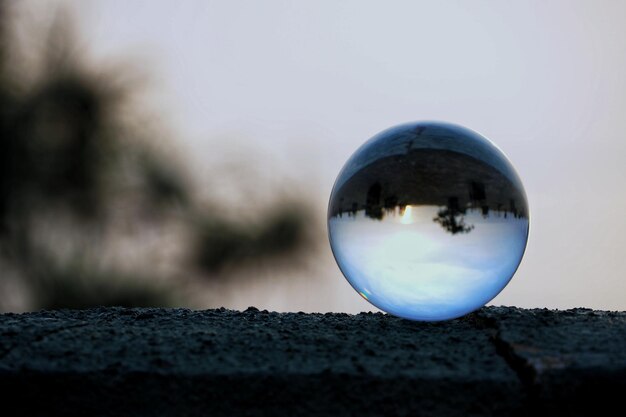 Close-up d'une boule de cristal sur le mur de soutènement contre le ciel au crépuscule