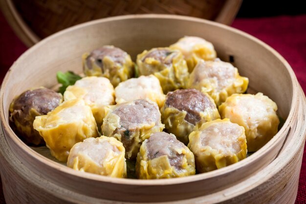 Photo close-up de boulettes chinoises dans un récipient en bambou sur une nappe de table