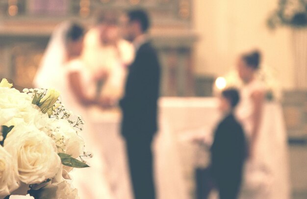 Photo close-up d'un bouquet avec un couple se mariant en arrière-plan